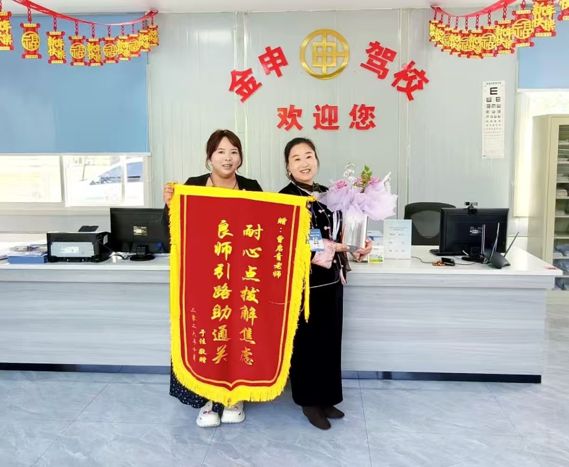 10月19日，顺利考取驾驶证的学员于女士专程来到金申驾校，将一面锦旗与一束鲜花送到教练员曾启青手中。鲜红锦旗字字暖心，既是学员对教练专业教学、贴心陪伴的高度肯定，更是金申驾校教练员队伍恪尽职守、爱岗敬业的鲜活见证。
